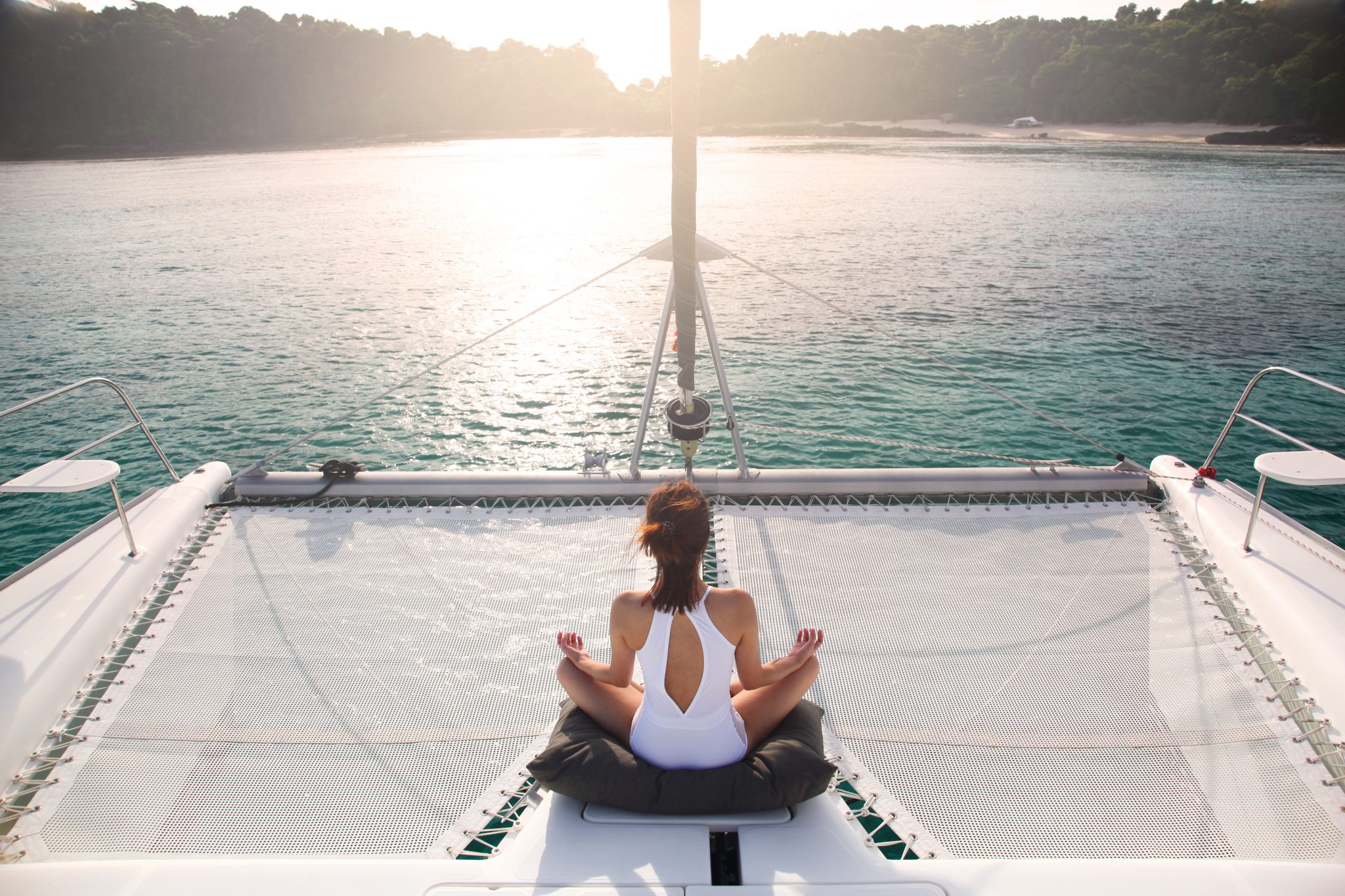 Women,Wear,White,Swimsuits.,Meditation,On,A,Catamaran,Sailboat.,Private